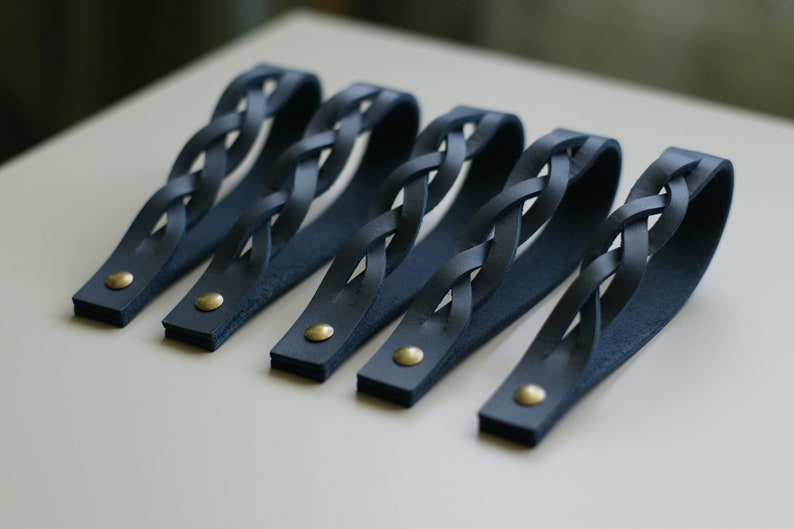 May include: Five dark blue leather drawer pulls with a braided design and gold metal accents.
