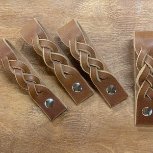 May include: Four brown leather braided drawer pulls with silver metal accents.