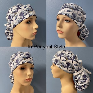 May include: A surgical scrub hat with a blue and white wave pattern. The hat is shown in a ponytail style, with the back of the hat gathered into a bun.