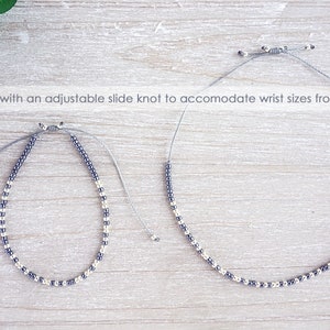 May include: Two beaded bracelets with a silver and black color scheme. The bracelets are made with an adjustable slide knot to fit wrist sizes from 5 1/2 inches to 10 inches.