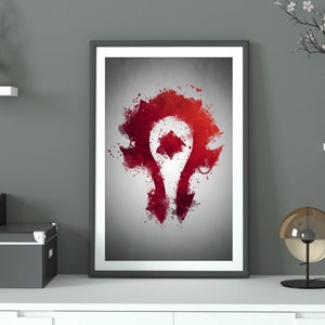 Puede incluir: Una impresión enmarcada de un diseño abstracto en rojo y blanco que representa el símbolo de la Horda del videojuego World of Warcraft. El símbolo es una H estilizada con un esquema de color rojo y blanco.