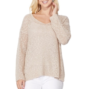 May include: A beige knitted sweater with a V-neck and long sleeves. The sweater is loose fitting and has a slightly cropped hem.