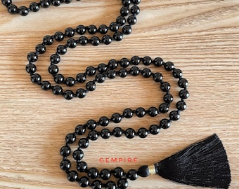 Puede incluir: Collar mala de cuentas de ónix negro con borla negra. La mala tiene aproximadamente 108 cuentas y está enhebrada en un cordón negro.