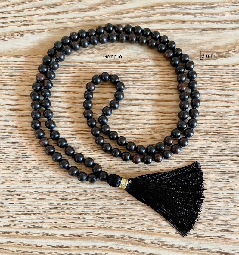May include: Black wooden beaded necklace with a black tassel. The beads are 6 mm in diameter. Gempire.