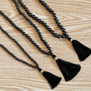 May include: Three black wooden bead necklaces with tassels. The necklaces are 6 mm, 8 mm, and 10 mm in diameter.