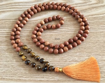May include: A brown wooden mala necklace with a tassel and tiger's eye beads.