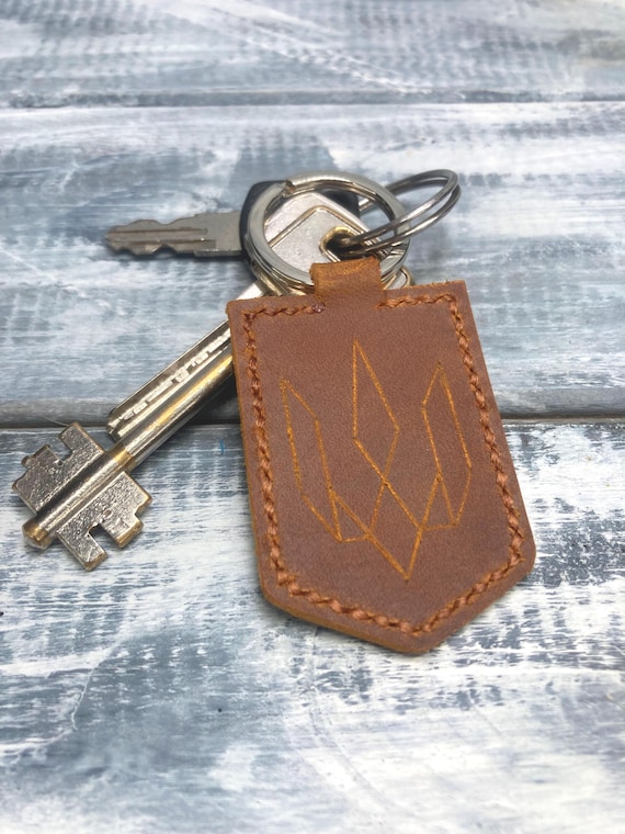 A leather keychain engraved with the Ukrainian coat of arms — a small, meaningful piece of wearable solidarity that doubles as genuine craft.