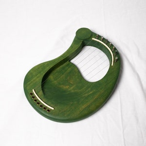 May include: A green wooden lyre with strings and gold tuning pegs.