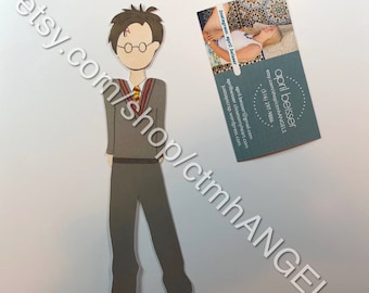 May include: A papercraft figure of a character wearing a grey sweater, a red and yellow striped tie, and black pants. The figure has a lightning bolt scar on their forehead and is wearing round glasses.