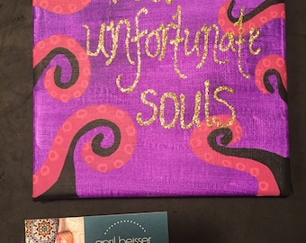 May include: Purple canvas painting with black and pink swirling lines. The words "Poor unfortunate souls" are written in gold glitter.