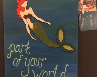 May include: A green mermaid with red hair and a purple seashell bra, swimming in a blue ocean with glitter. The text "part of your world" is written in green below the mermaid.