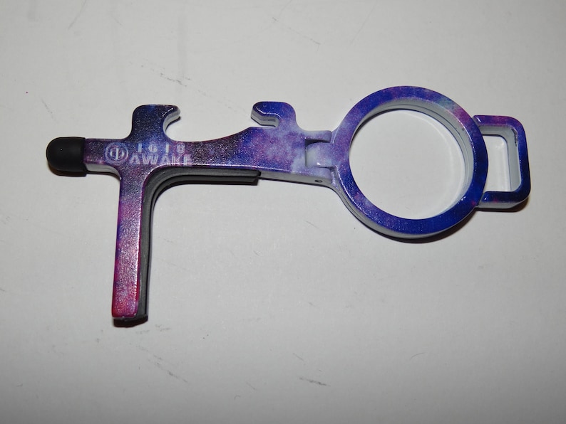 May include: A purple and blue galaxy-printed multi-tool with a stylus, bottle opener, and a loop for attaching to a keyring. The tool is labelled "IG19 AWAKE".