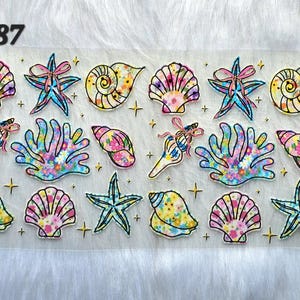 May include: A sheet of colorful, transparent stickers featuring various sea-themed designs. The stickers include seashells, starfish, and coral, with vibrant pink, blue, yellow, and green hues. The text "#687" is in the upper left corner.
