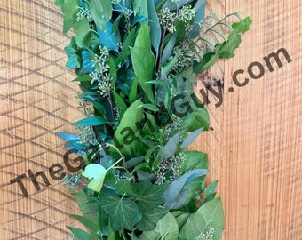 Puede incluir: Una guirnalda verde exuberante hecha de eucalipto, hiedra y otras plantas verdes. La guirnalda es perfecta para agregar un toque de naturaleza a la decoración de tu hogar.