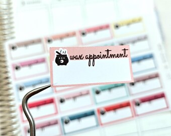 Puede incluir: Una pegatina rosa y blanca con un caldero negro y el texto "wax appointment".