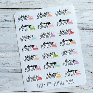 May include: A sheet of stickers with the text "change bedding" and a bed icon in various colors. The stickers are designed for use in a planner or journal.