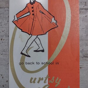 May include: A rectangular advertisement featuring a stylized illustration of a person wearing an orange coat with black buttons, a dark hat, and dark shoes. The text reads "go back to school in" and "urtsy Coats" in gold and black lettering.