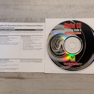 May include: A Digital CD Recording Studio II Professional Edition software disc and its accompanying white paper installation and support guide. The disc features black and silver graphics with rainbow light reflections and printed text.