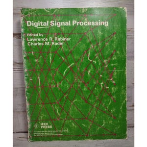 May include: A green softcover book titled Digital Signal Processing, edited by Lawrence R. Rabiner and Charles M. Rader. The cover features a red geometric grid pattern of interconnected lines and dots, with the IEEE Press logo at the bottom.