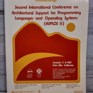 May include: A softcover book titled Proceedings Second International Conference on Architectural Support for Programming Languages and Operating Systems (ASPLOS II) from October 1987, featuring a red and yellow mountain graphic on a cream background.