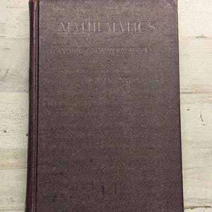 May include: A dark brown hardcover book titled Mathematics of Radio Communications by T.J. Wang. The front cover features embossed text in a serif font, with the title at the top, the subtitle below, and the author's name centered on the cover.