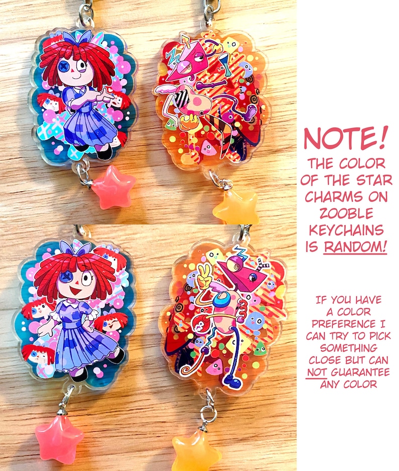 May include: Four Zooble keychains with cartoon character designs. Two keychains feature a doll-like character in a blue dress, and the other two have a colorful abstract design. Each keychain has a star charm. The text on the image states that the star charm color is random.