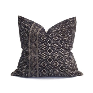 May include: Black and white patterned throw pillow with a geometric design. The pillow is made of a soft, woven fabric.