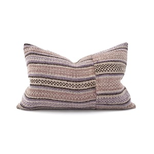 May include: A striped throw pillow with a woven texture in shades of purple, brown, and beige.