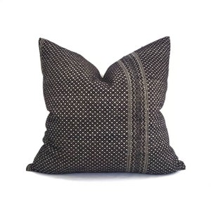 May include: Black and white patterned throw pillow with a geometric design. The pillow is made of a soft, woven fabric.