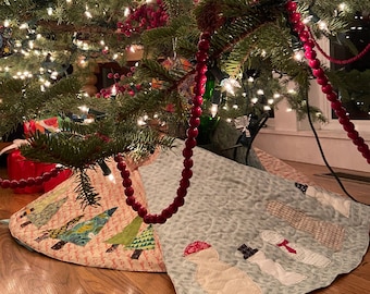 May include: A Christmas tree skirt with a patchwork design featuring a variety of fabrics and colors. The skirt is decorated with a red beaded garland and features a snowman and other winter-themed designs.