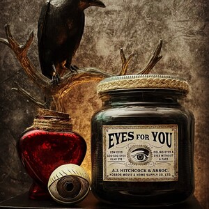 May include: A dark glass jar with a label reading EYES FOR YOU, A.J. HITCHCOCK & ASSOC. HORROR MOVIE & HOME SUPPLY CO. LTD., featuring a central eye illustration. Beside it sits a red heart-shaped bottle, a spherical eye prop, and a black raven figure.