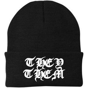 May include: Black beanie with a white embroidered design that says "THEM THEM" in a gothic font.