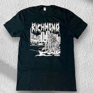 Puede incluir: Camiseta negra con un gráfico blanco de un monstruo frente a un paisaje urbano con el texto "RICHMOND VIRGINIA".