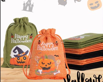 May include: Two drawstring Halloween gift bags, one green and one orange, with pumpkin and witch hat graphics. The bags have the words "Happy Halloween" printed on them. A stack of green and black Halloween-themed cards is also visible.