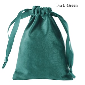 May include: A dark green velvet drawstring bag with a satin ribbon closure. The bag is empty and ready to be filled with gifts or small items.