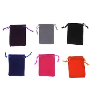 May include: Six small velvet drawstring bags in various colors. The bags are purple, gray, black, blue, pink, and orange.