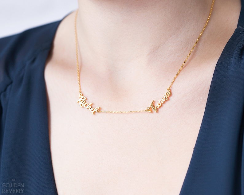 May include: Gold necklace with two names, "Rachel" and "Theresa", written in cursive script.