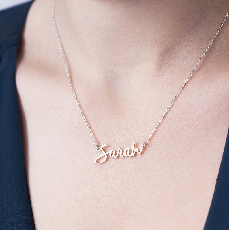 Op de afbeelding: Een zilveren ketting met de naam "Sarah" in een cursief schrift.