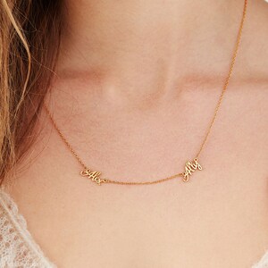 Op de afbeelding: Gouden ketting met twee namen, "Alex" en "Ally", geschreven in cursief.