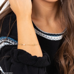 K&ouml;nnte beinhalten: Goldkette Armband mit den Namen "Anne" und "Kate" in Kursivschrift.