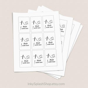 Puede incluir: Hojas de etiquetas blancas con un dise&ntilde;o negro de aguja e hilo, un coraz&oacute;n y las palabras "Made with love". Las etiquetas son rectangulares. La URL de la tienda Etsy es visible en la parte inferior.