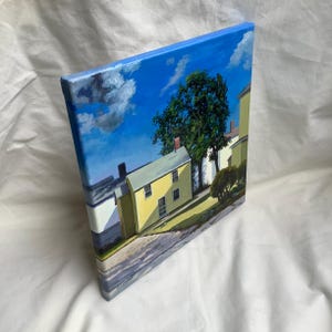 May include: A painting of a yellow house with a green tree in front of it. The house has a blue roof and white trim. The sky is blue with white clouds.