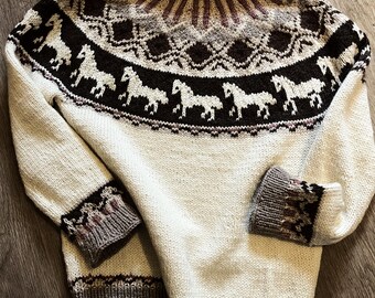 May include: Cream-colored sweater with a high neck and long sleeves. The design features a band of white horses on a dark brown background, with geometric patterns in shades of brown, gray, and burgundy around the neck and cuffs. The sweater is made of a knitted material.