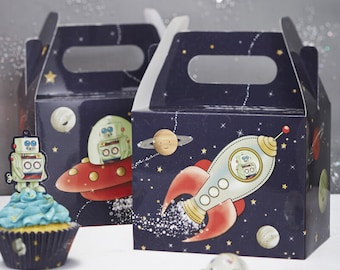 May include: Two blue and white cardboard party favor boxes with a space theme. The boxes feature a rocket, a flying saucer, and robots. The boxes have a handle on the top.