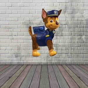 May include: A brown and tan cartoon dog wearing a blue and yellow police uniform with a blue hat. The dog is standing on a white brick wall background.