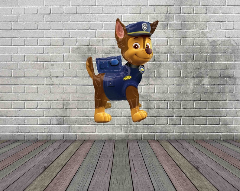 May include: A brown and tan cartoon dog wearing a blue and yellow police uniform with a blue hat. The dog is standing on a white brick wall background.