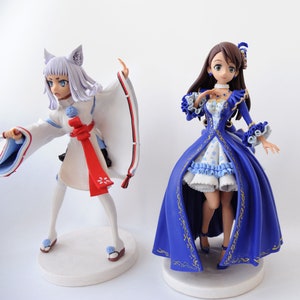 K&ouml;nnte beinhalten: Zwei Anime-Figuren. Eine ist eine wei&szlig; gekleidete Figur mit Fuchsohren und einem roten Band. Die andere ist eine Frau in einem blau-wei&szlig;en Kleid mit goldenen Akzenten. Beide Figuren stehen auf wei&szlig;en, kreisf&ouml;rmigen Sockeln.