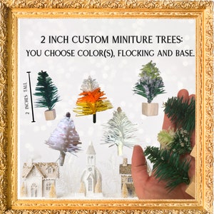 Puede incluir: Seis árboles de Navidad en miniatura de diferentes colores, incluyendo verde, blanco, naranja y amarillo. Los árboles miden 5 cm de alto y se muestran sobre un fondo blanco. El texto "2 INCH CUSTOM MINITURE TREES: YOU CHOOSE COLOR(S), FLOCKING AND BASE." se muestra en la parte superior de la imagen.
