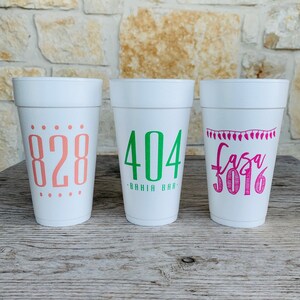 May include: Three white foam cups with custom text. The left cup features the number 828 in coral. The center cup displays 404 BAHIA BAR in green. The right cup shows a string of lights graphic above the text Casa 3016 in bright pink ink.