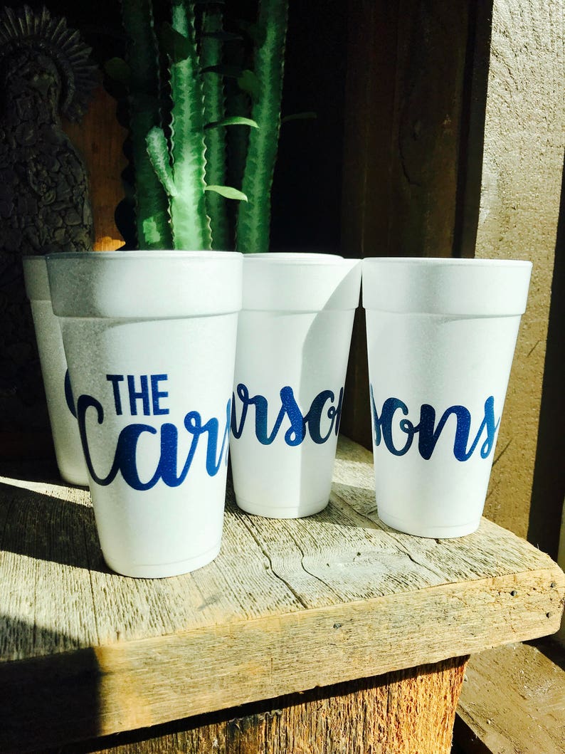 May include: Three white foam cups featuring the blue text "THE CARSONS" printed in a cursive script font. The cups are arranged in a row, displaying the personalized name across the front surface of each individual white polystyrene container.